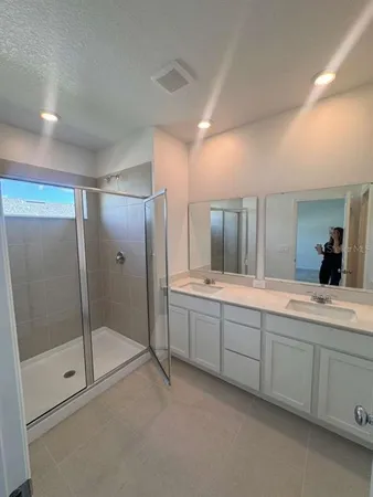 a large bathroom with a large mirror vanity and shower