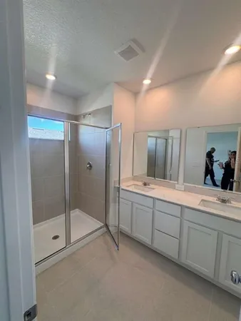 a spacious bathroom with a mirror and a shower