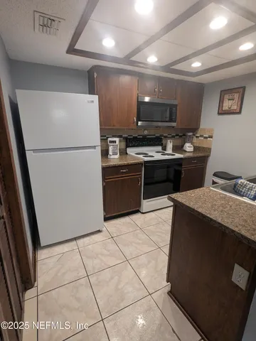 a kitchen with stainless steel appliances granite countertop a refrigerator stove top oven and sink