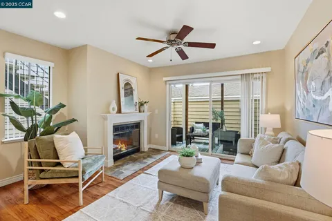 a living room with furniture fireplace and a large window