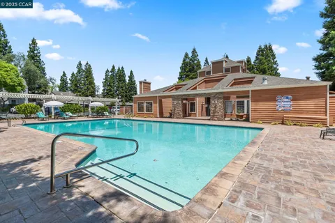a view of backyard with swimming pool and seating space
