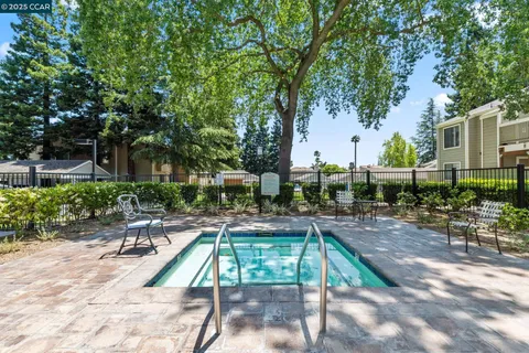 a view of a swimming pool with lounge chairs in patio
