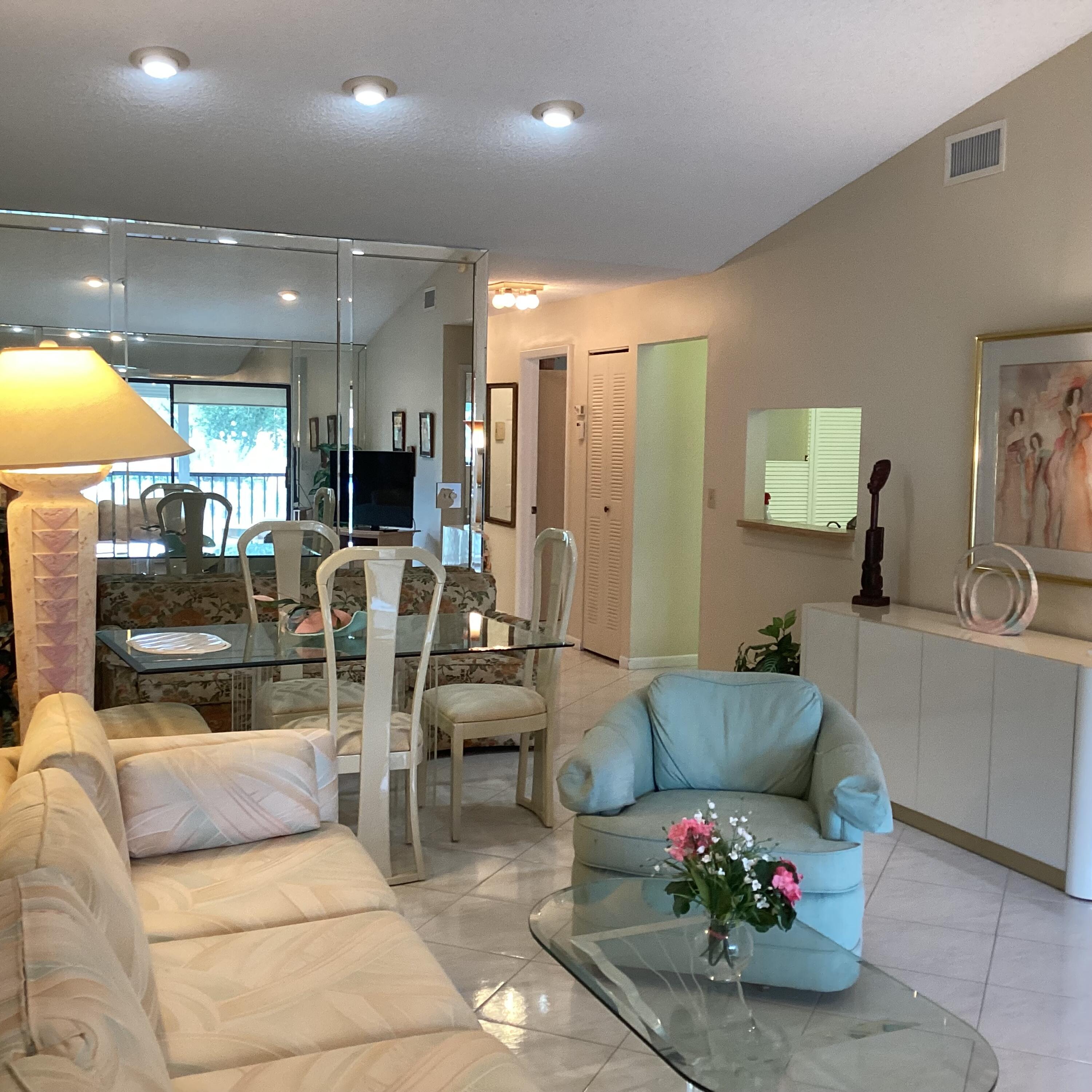 15235 Lakes Of Delray Boulevard, Unit 303 Delray Beach, FL 33484 - Photo 12 of 24 a living room with furniture and a chandelier