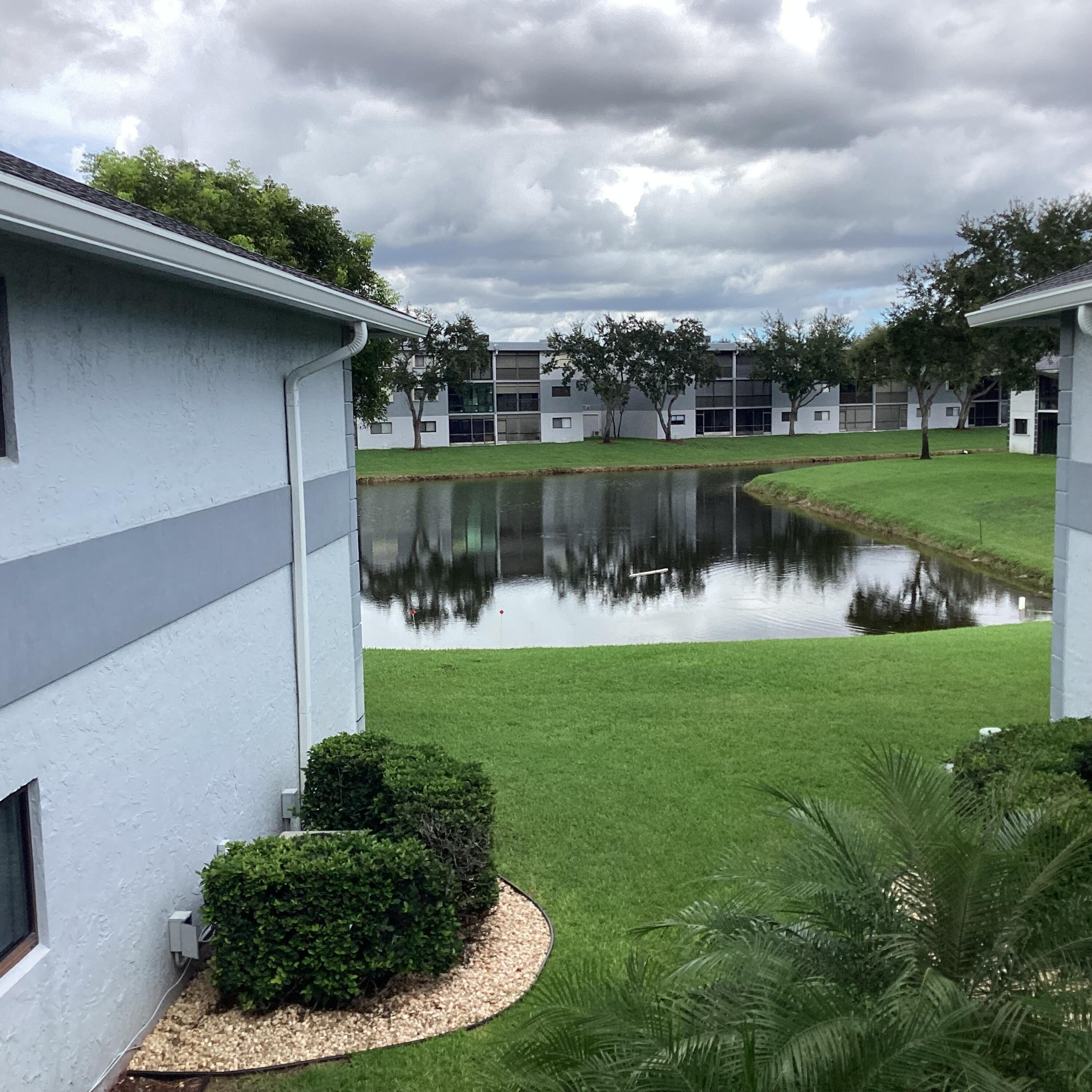 15235 Lakes Of Delray Boulevard, Unit 303 Delray Beach, FL 33484 - Photo 3 of 24 a view of a lake with a house in the background