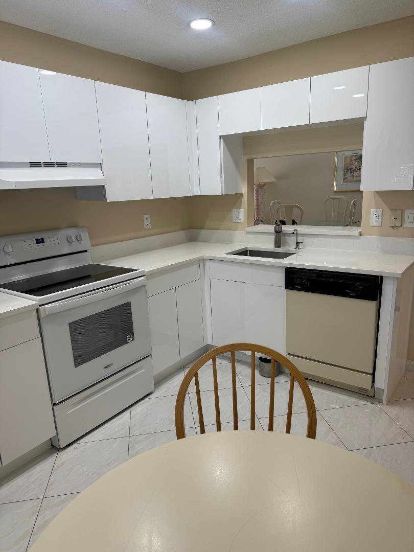 15235 Lakes Of Delray Boulevard, Unit 303 Delray Beach, FL 33484 - Photo 4 of 24 a kitchen with stainless steel appliances granite countertop a sink a stove and cabinets
