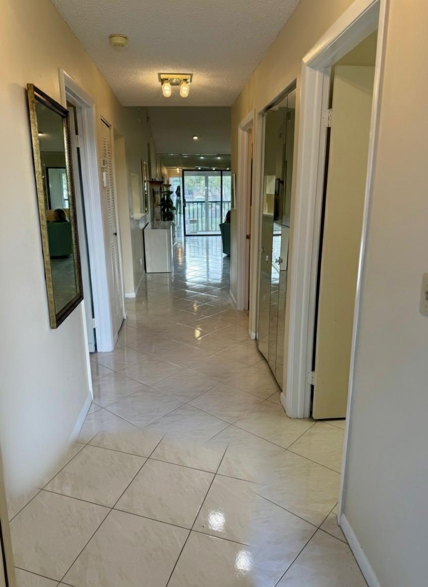 15235 Lakes Of Delray Boulevard, Unit 303 Delray Beach, FL 33484 - Photo 6 of 24 a view of a hallway with wooden floor and a bathroom