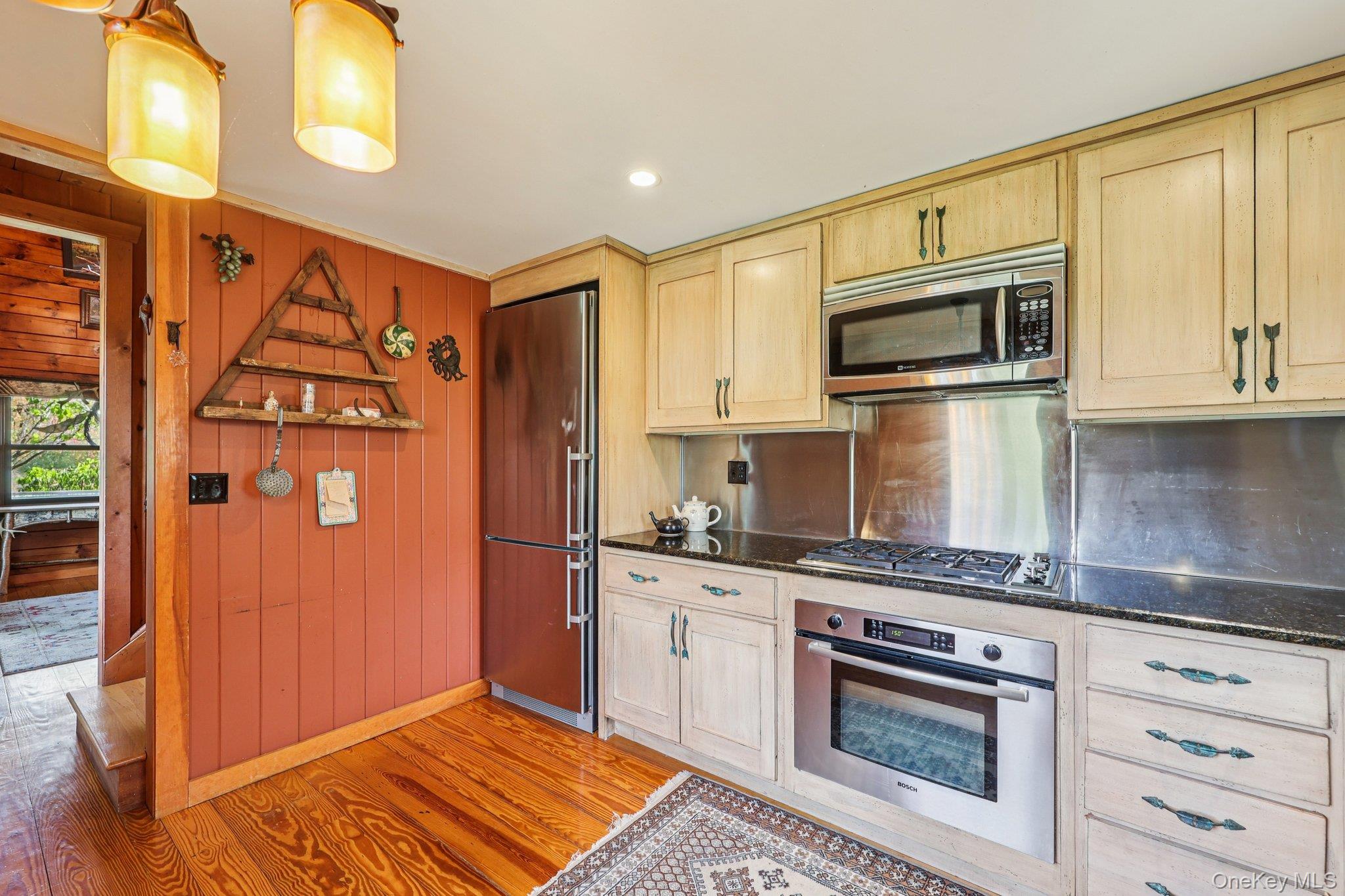 101 Upper Wisner Road Warwick, NY 10990 - Photo 11 of 48 Kitchen with light brown cabinetry, stainless steel appliances, light wood-style floors, wood walls, and dark stone countertops