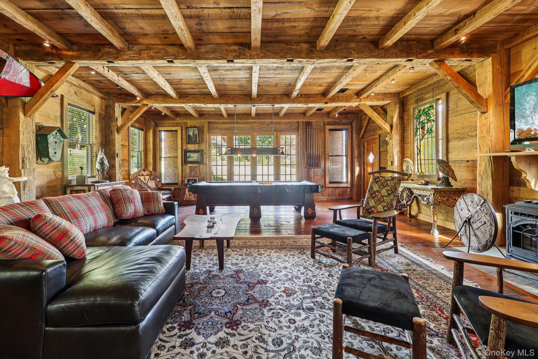 101 Upper Wisner Road Warwick, NY 10990 - Photo 21 of 48 Living area with a wooden ceiling with exposed beams, plenty of natural light, wood finished floors, a wood stove, and wood walls