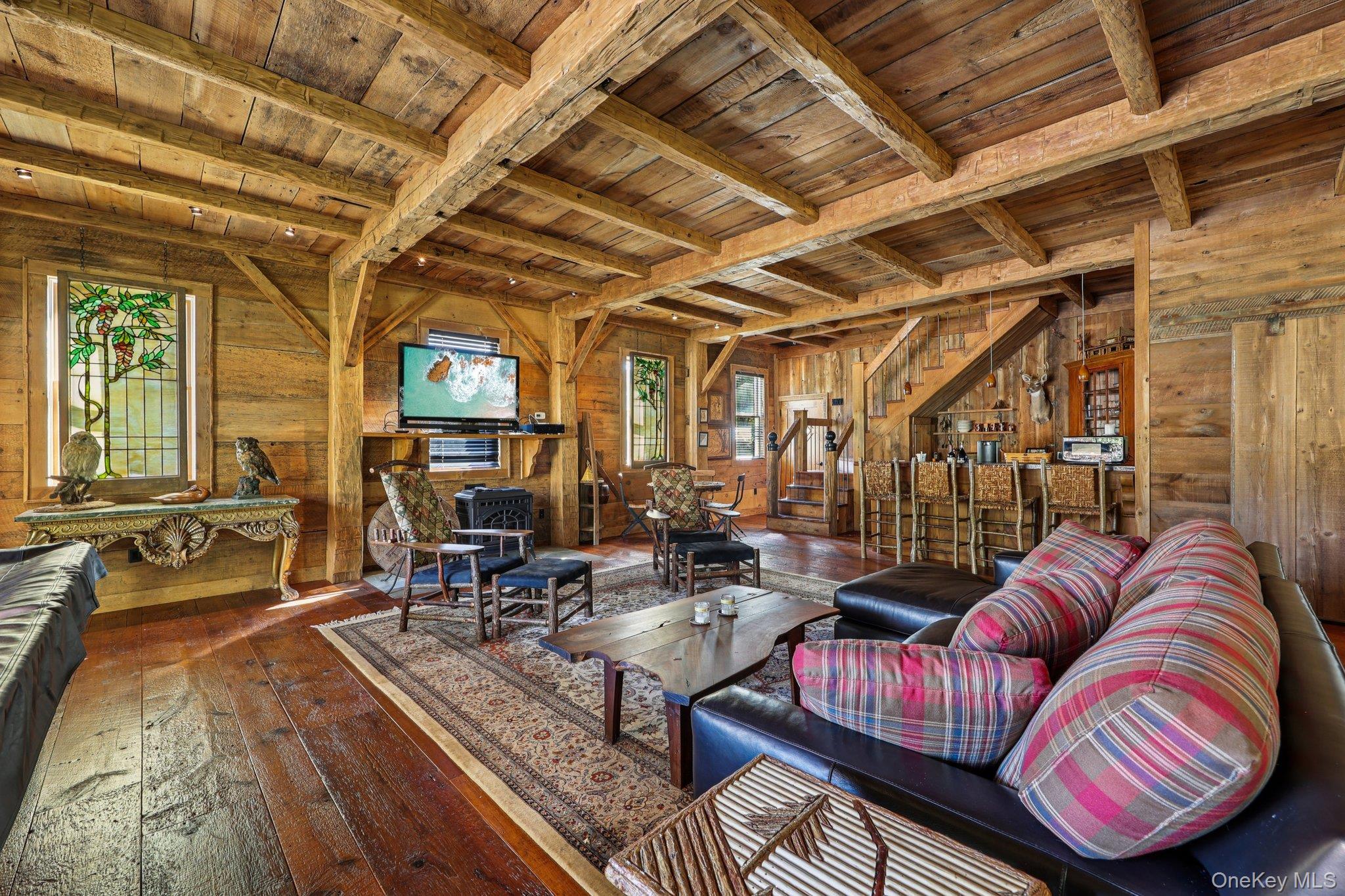 101 Upper Wisner Road Warwick, NY 10990 - Photo 23 of 48 Living room featuring a wood ceiling with exposed beams, wood-type flooring, stairway, and wooden walls