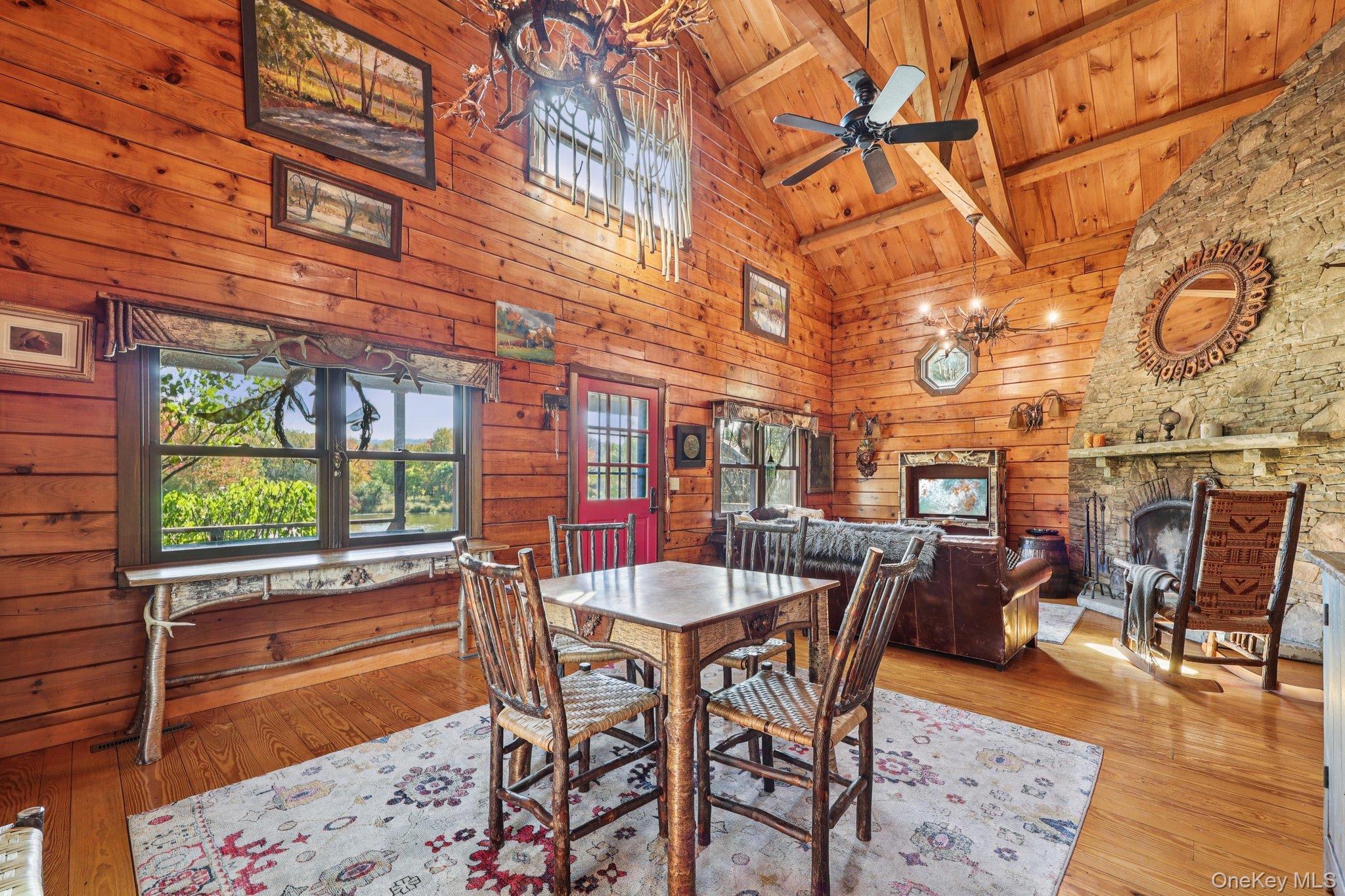 101 Upper Wisner Road Warwick, NY 10990 - Photo 10 of 48 Dining room with wood walls, a fireplace, wood-type flooring, high vaulted ceiling, and healthy amount of natural light