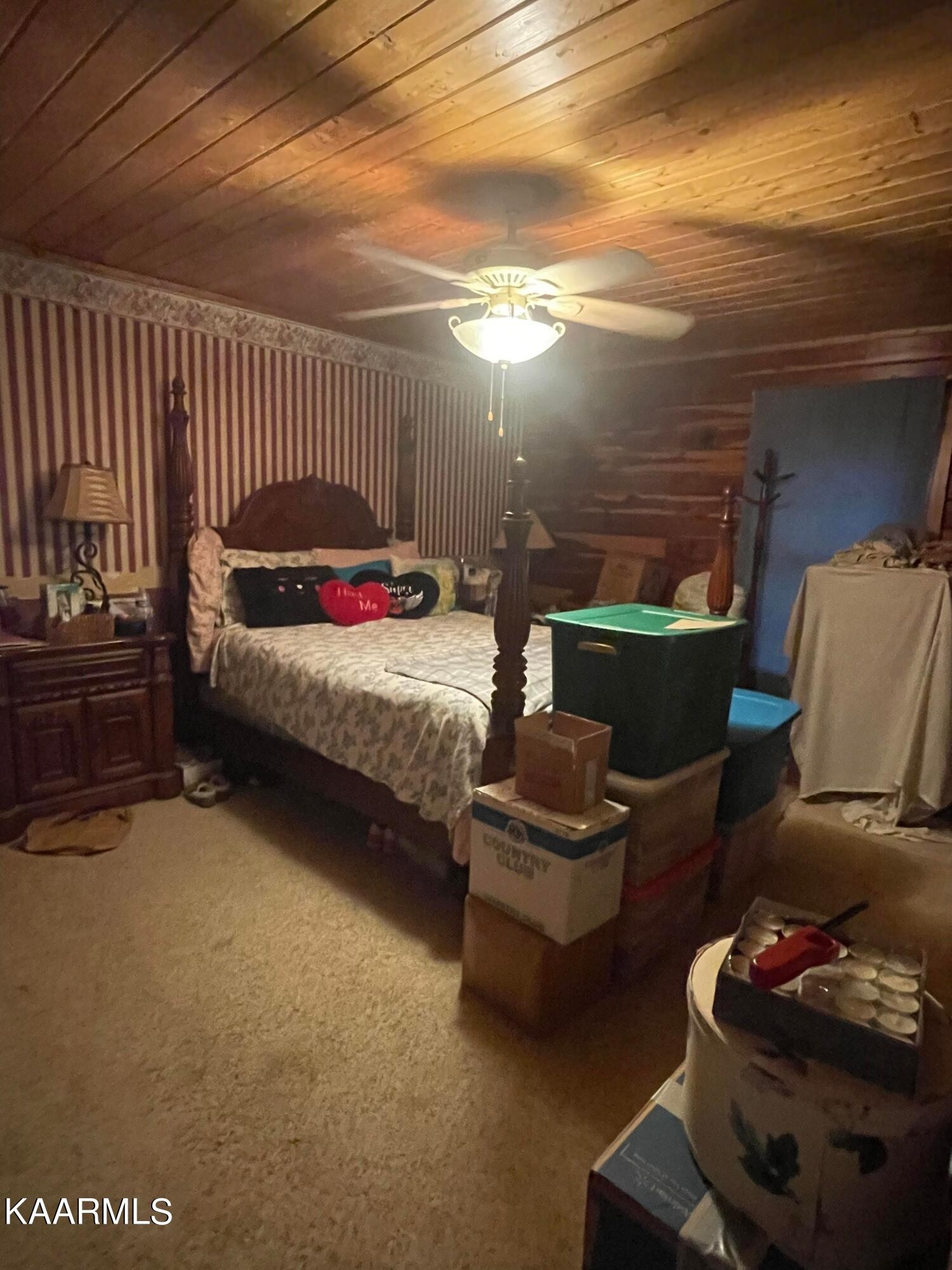3879 Roan Creek Road Lobelville, TN 37097 - Photo 28 of 45 a bedroom with furniture and a lamp