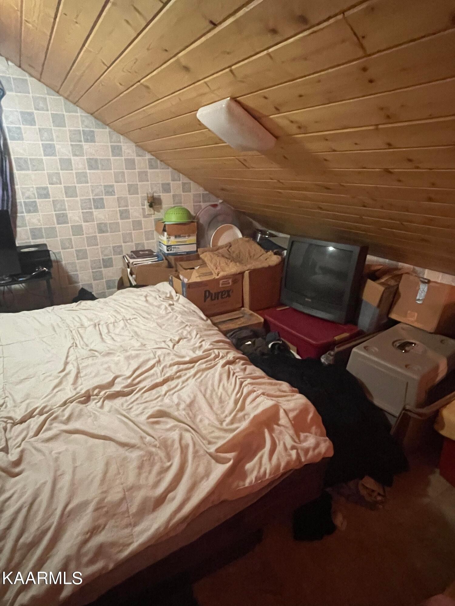3879 Roan Creek Road Lobelville, TN 37097 - Photo 37 of 45 a bed sitting in a bedroom next to a lamp