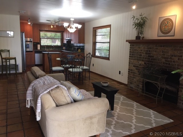 6312 River Road New Smyrna Beach, FL 32169 - Photo 28 of 33 a living room with furniture a window and a fireplace