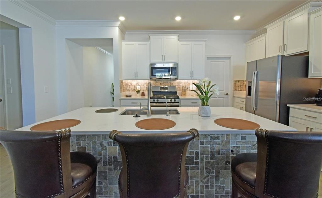 17304 Banded Gold Lane Wimauma, FL 33598 - Photo 15 of 44 a kitchen with stainless steel appliances granite countertop a sink and a refrigerator