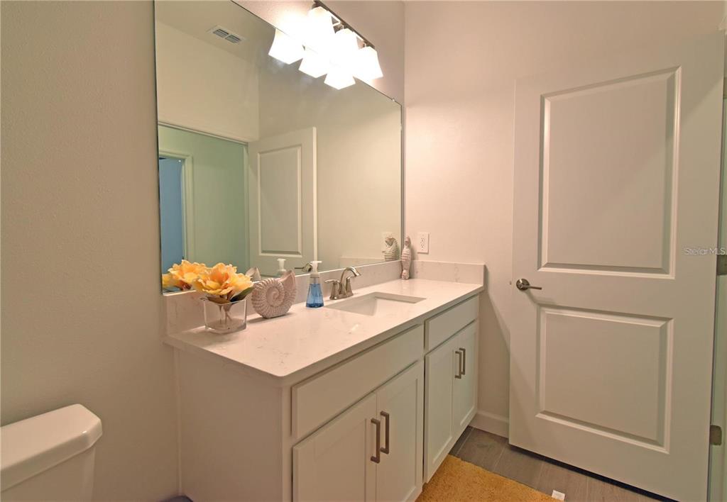 17304 Banded Gold Lane Wimauma, FL 33598 - Photo 32 of 44 a bathroom with a sink toilet and mirror