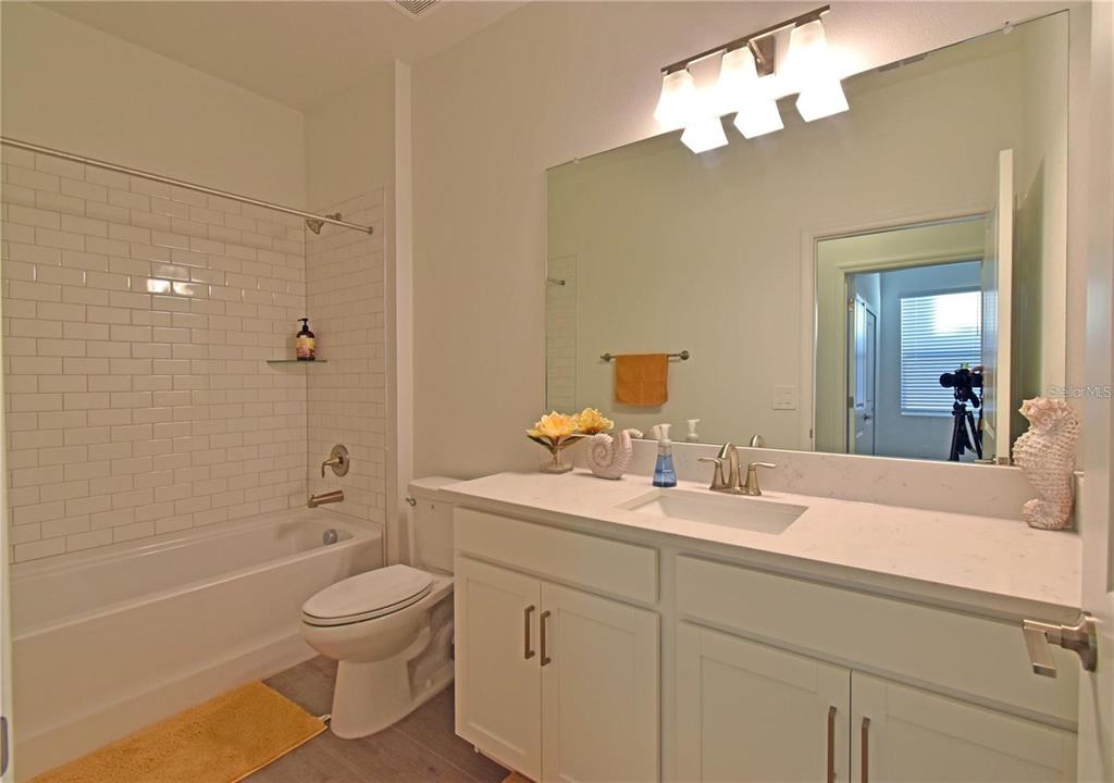 17304 Banded Gold Lane Wimauma, FL 33598 - Photo 33 of 44 a bathroom with a sink a toilet and a mirror