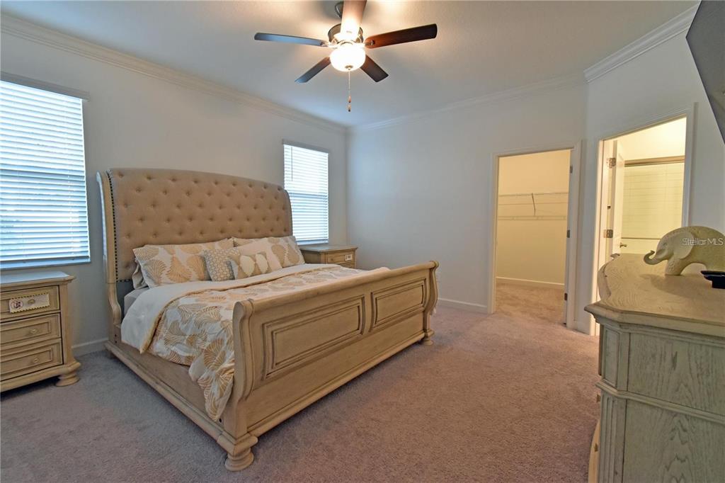 17304 Banded Gold Lane Wimauma, FL 33598 - Photo 34 of 44 a spacious bedroom with a bed and a dresser