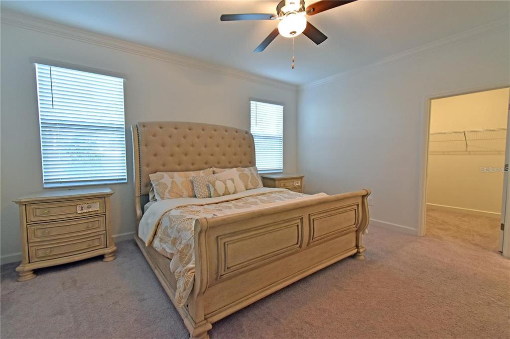 17304 Banded Gold Lane Wimauma, FL 33598 - Photo 35 of 44 a bedroom with a bed and a chandelier