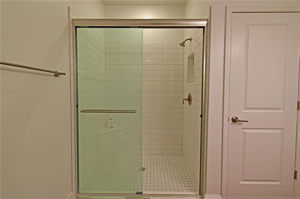 17304 Banded Gold Lane Wimauma, FL 33598 - Photo 40 of 44 a bathroom with a glass shower door
