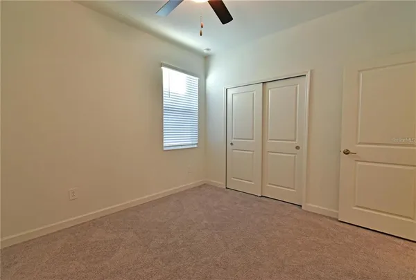 an empty room with chandelier fan