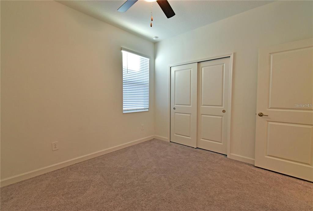 17304 Banded Gold Lane Wimauma, FL 33598 - Photo 41 of 44 an empty room with chandelier fan
