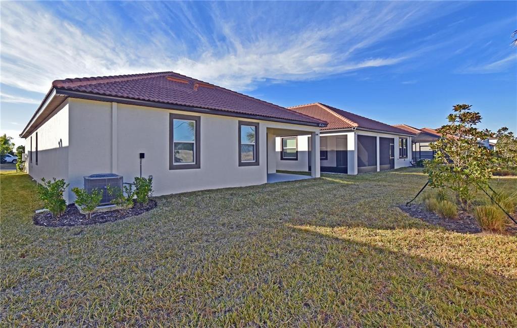 17304 Banded Gold Lane Wimauma, FL 33598 - Photo 6 of 44 a front view of a house with a garden