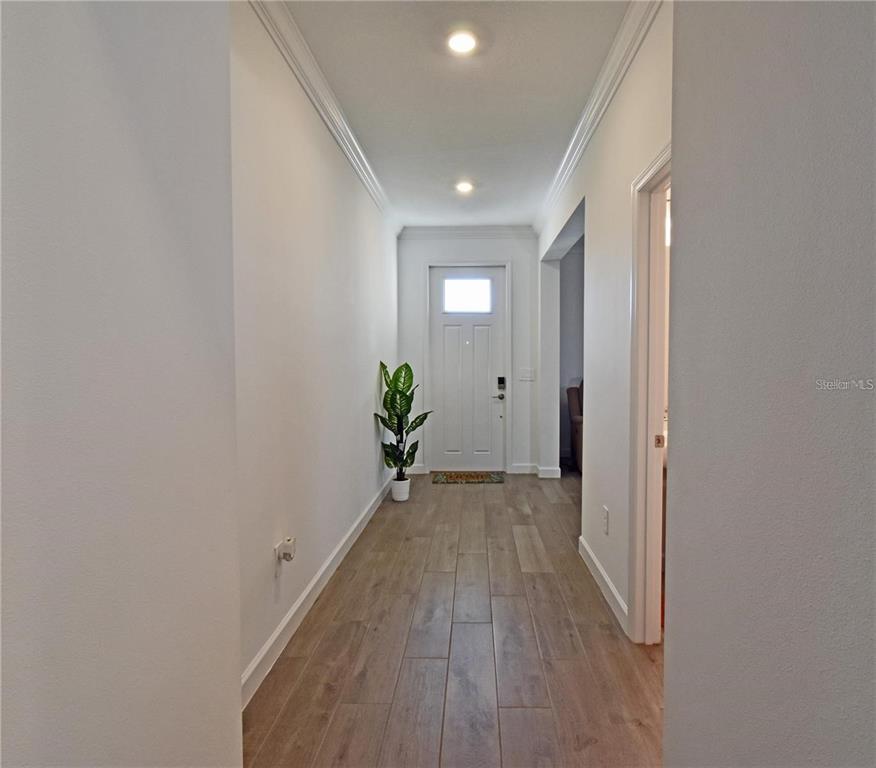 17304 Banded Gold Lane Wimauma, FL 33598 - Photo 10 of 44 a view of a hallway with wooden floor