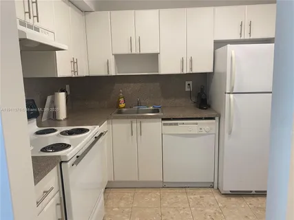 a kitchen with appliances a sink and cabinets