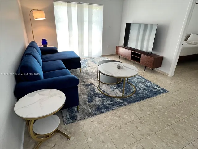 a living room with furniture a rug and a window