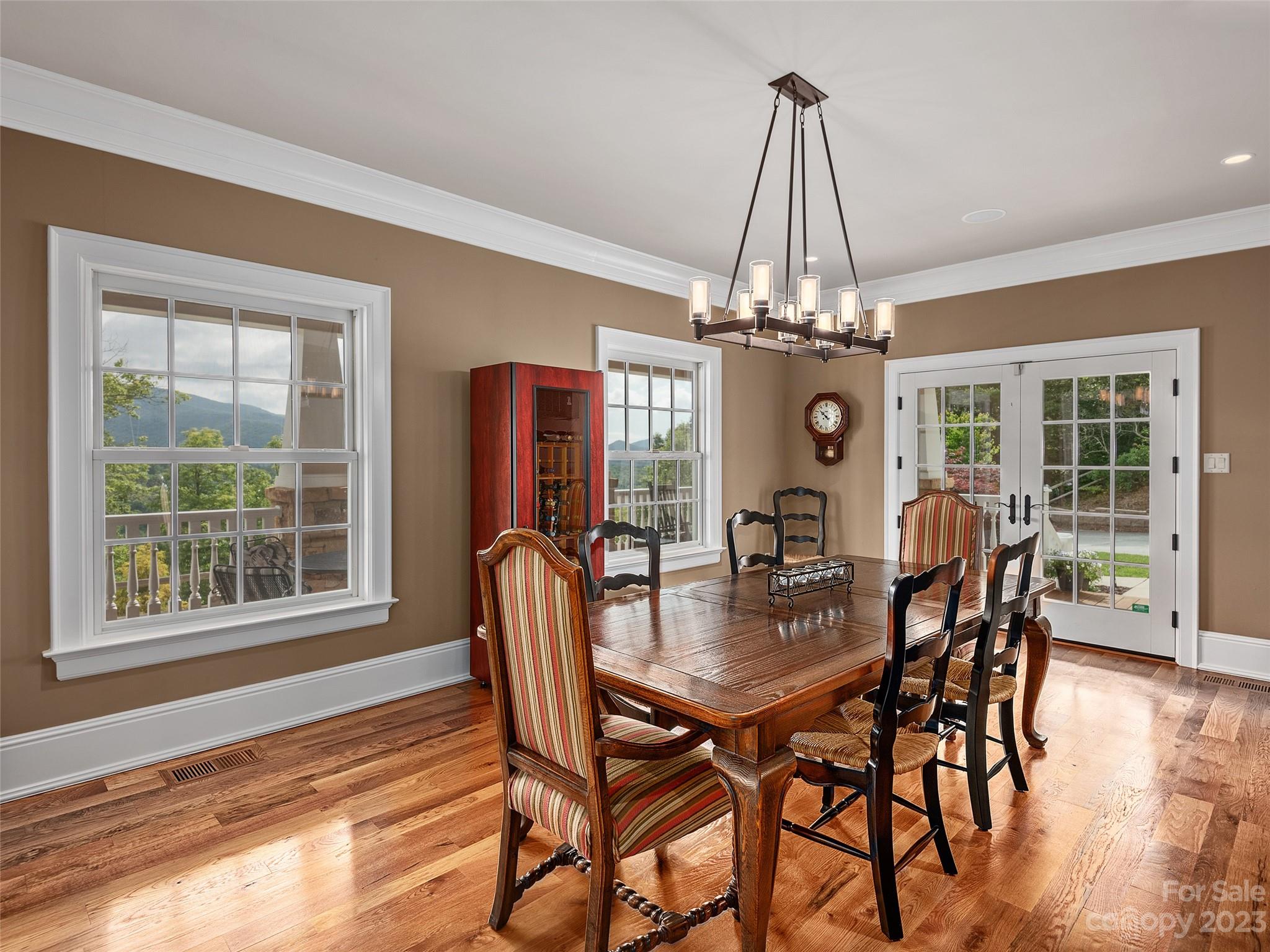113 Willow Farm Road Fairview, NC 28730 - Photo 16 of 48 a dining room with wooden floor a chandelier a wooden table and chairs