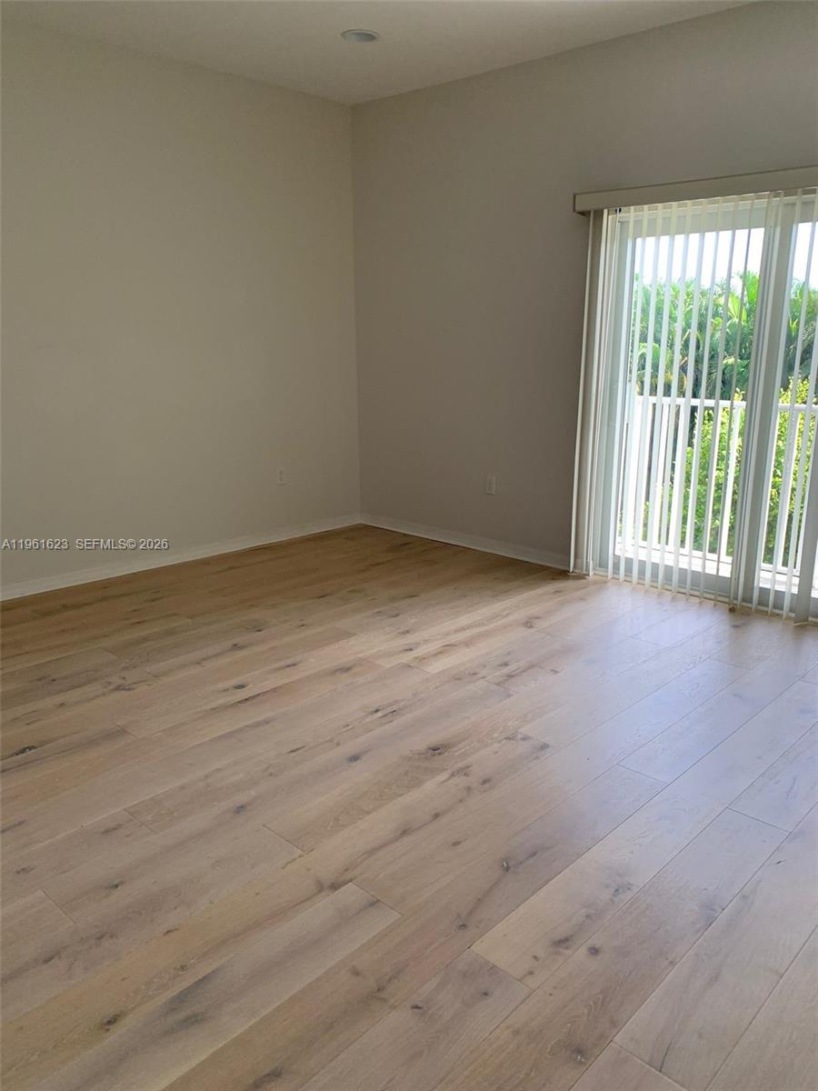 8416 West McNab Road, Unit 8416 Tamarac, FL 33321 - Photo 25 of 25 a view of an empty room with wooden floor and a window