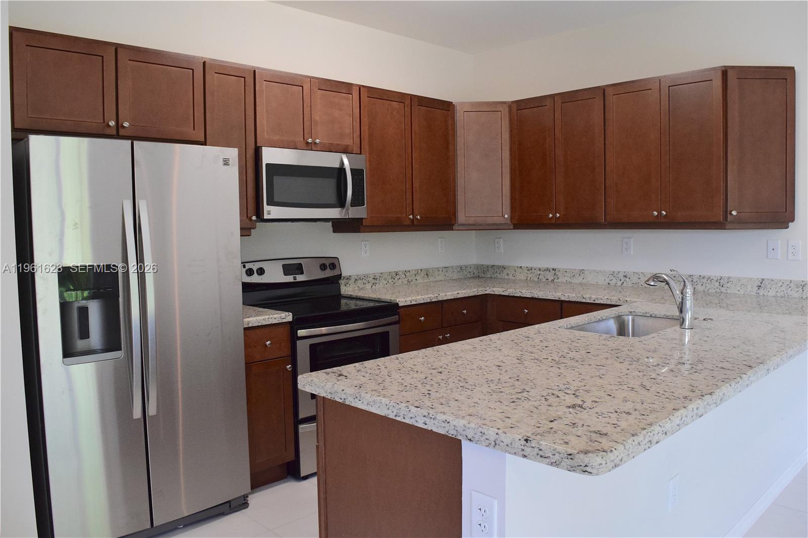 8416 West McNab Road, Unit 8416 Tamarac, FL 33321 - Photo 6 of 25 a kitchen with granite countertop a refrigerator a stove and a sink