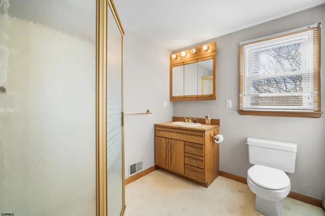 a bathroom with a toilet a sink and a mirror