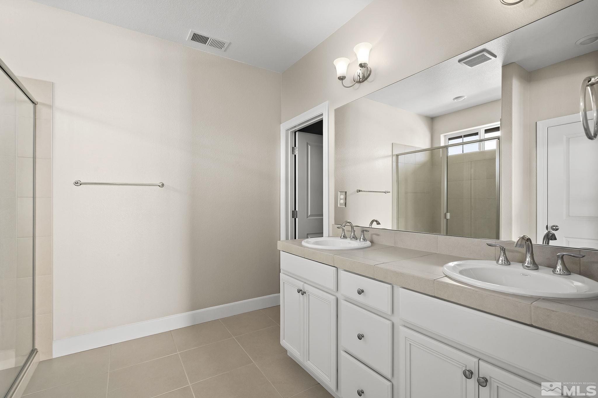 1855 Sea Horse Road, Unit A Reno, NV 89521 - Photo 13 of 32 a bathroom with a granite countertop sink and a mirror