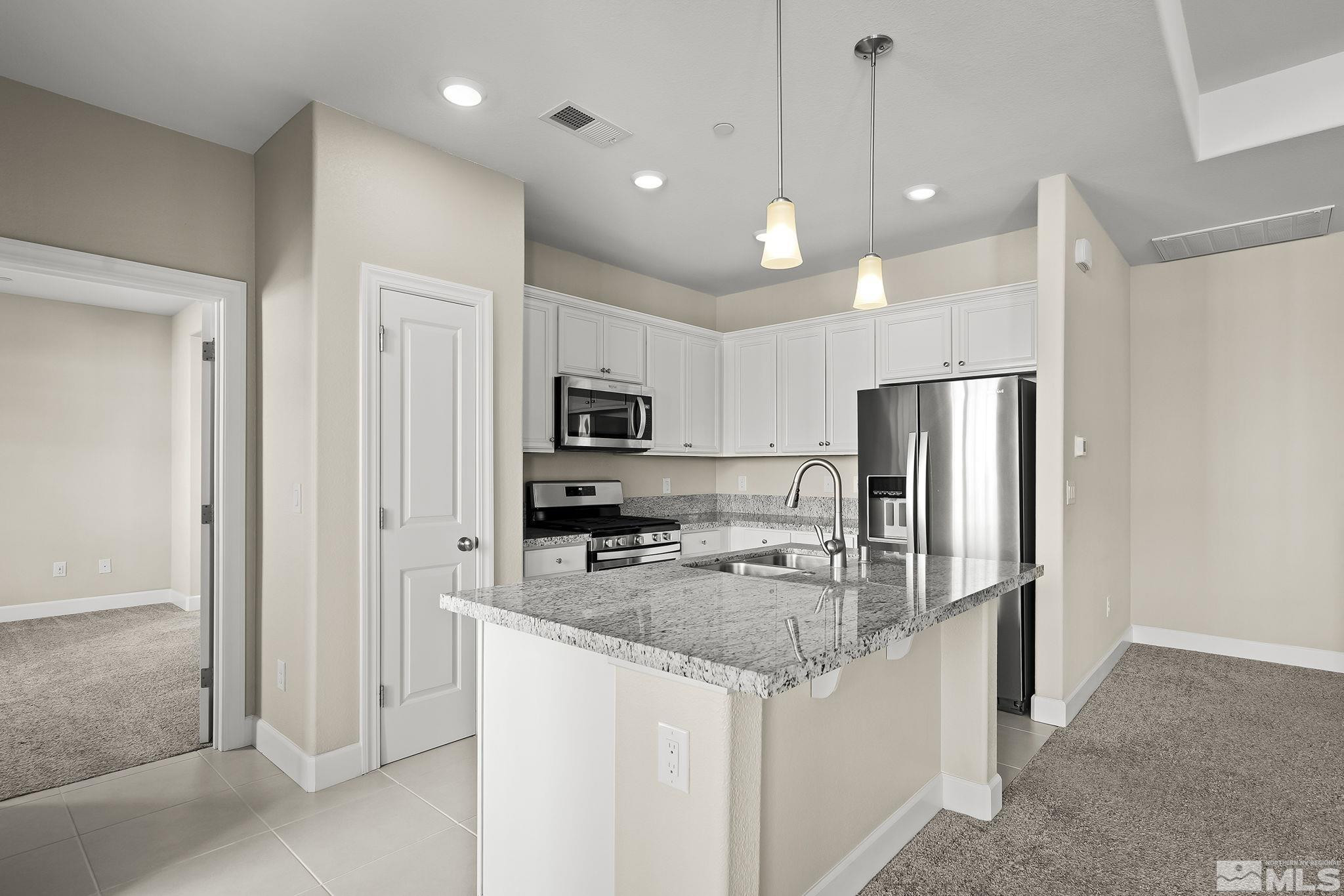 1855 Sea Horse Road, Unit A Reno, NV 89521 - Photo 8 of 32 a kitchen with stainless steel appliances granite countertop a refrigerator a stove a sink and a refrigerator
