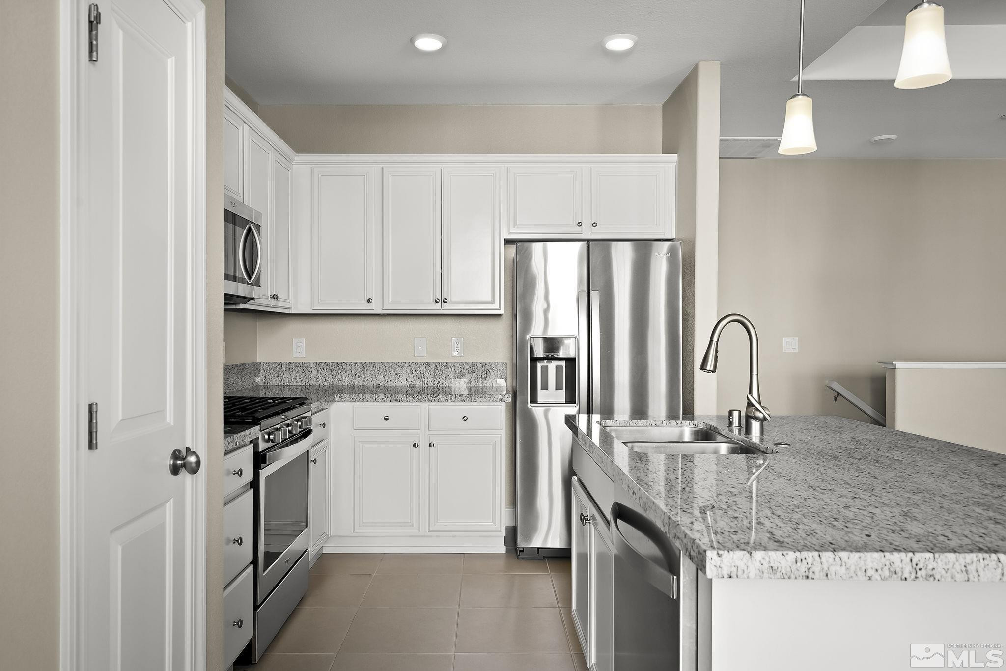 1855 Sea Horse Road, Unit A Reno, NV 89521 - Photo 10 of 32 a kitchen with stainless steel appliances granite countertop a sink stove and refrigerator