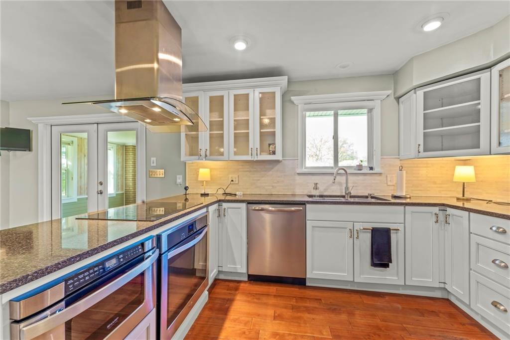 162 Ferncliff Road Rices Landing, PA 15357 - Photo 17 of 36 a large kitchen with granite countertop a sink and dishwasher a stove top oven with wooden floor