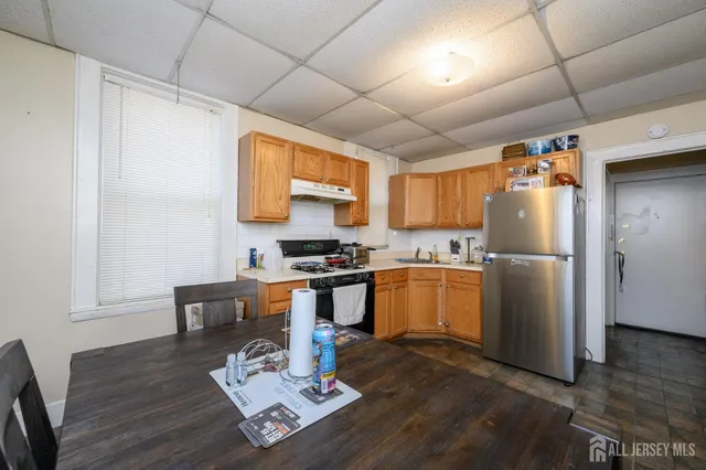 a kitchen with a refrigerator and a stove top oven