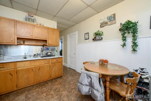 a kitchen with stainless steel appliances a sink a table and chairs in it