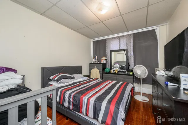 a bedroom with bed and wooden floor