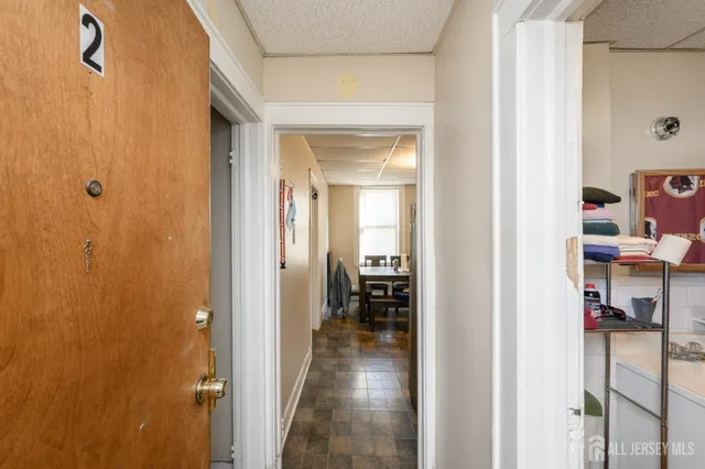 a view of a hallway with closet and a window