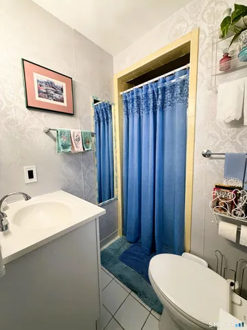 a bathroom with a sink a toilet a mirror and shower