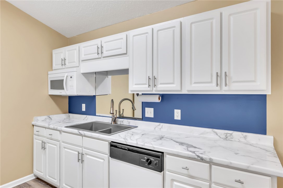 706 Pelham Square Way Greer, SC 29650 - Photo 11 of 20 This modern kitchen features crisp white cabinetry and sleek countertops, ready for culinary creativity.