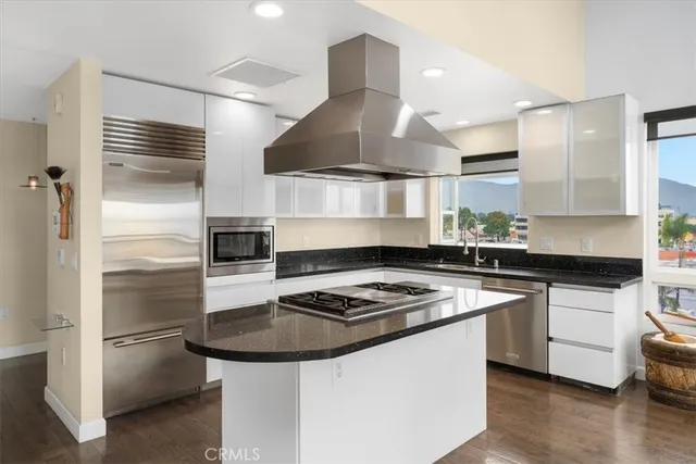 a kitchen with kitchen island stainless steel appliances a sink stove and refrigerator