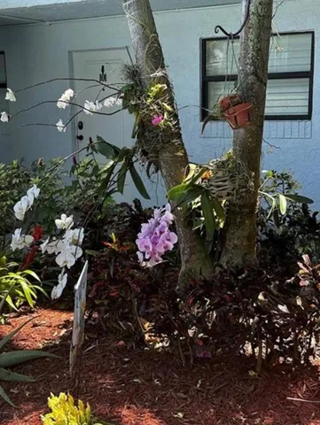 an aerial view of multi story residential apartment building with yard and parking spaces