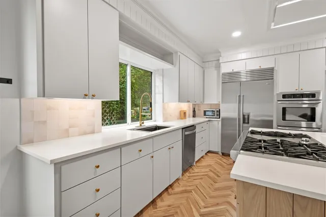a kitchen with appliances a sink and cabinets