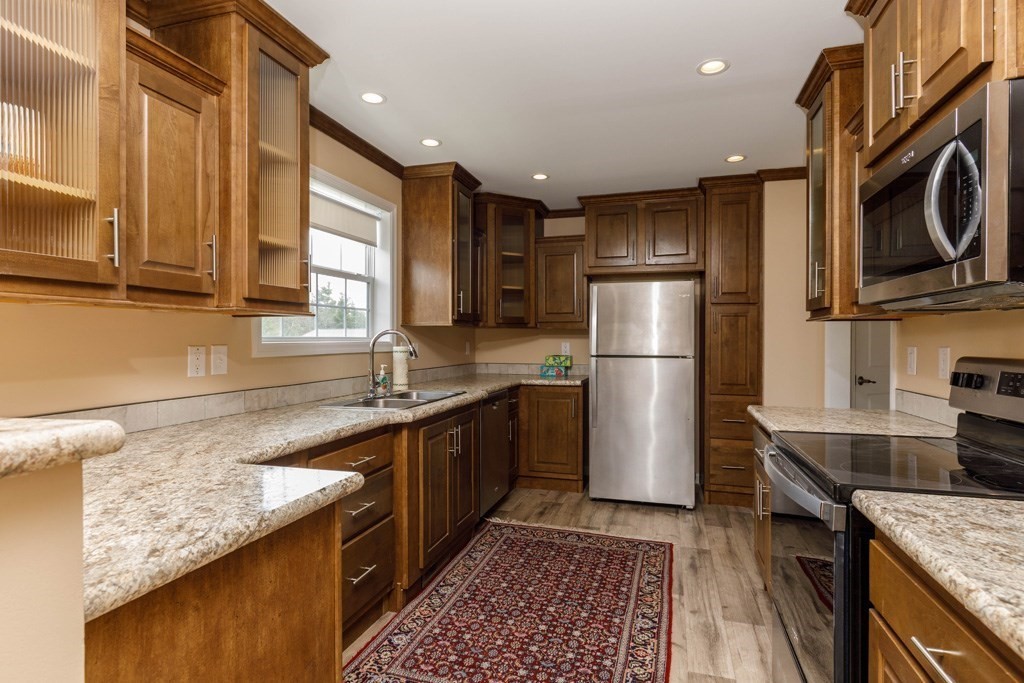 102 Topaz Terrace Gardner, MA 01440 - Photo 2 of 20 a kitchen with stainless steel appliances granite countertop a sink stove and refrigerator