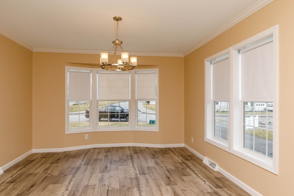 102 Topaz Terrace Gardner, MA 01440 - Photo 5 of 20 a view of an empty room with a window and wooden floor