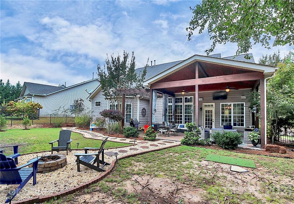 1339 Secret Path Drive Fort Mill, SC 29708 - Photo 5 of 46 a view of a backyard with table and chairs potted plants and large tree