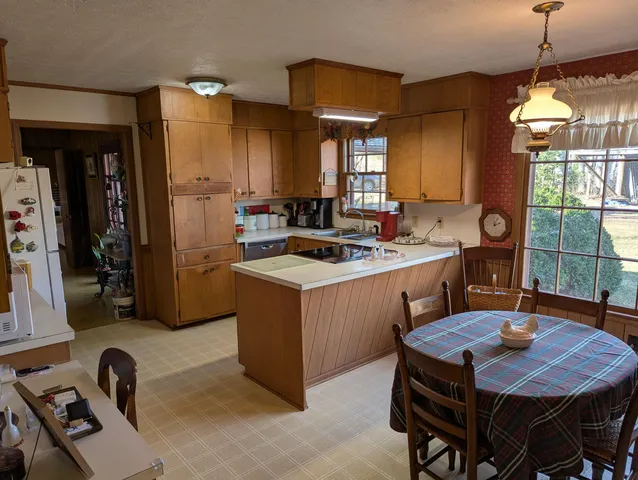 a kitchen that has a sink a stove a dining table and chairs